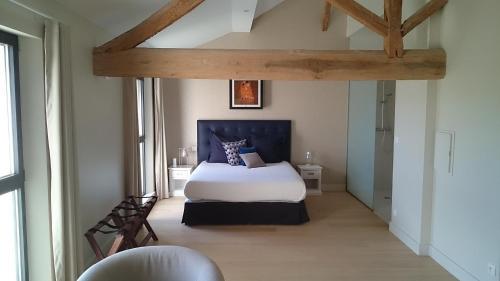 a bedroom with a white bed with a blue headboard at L'Atelier De Dégustation in Vertus