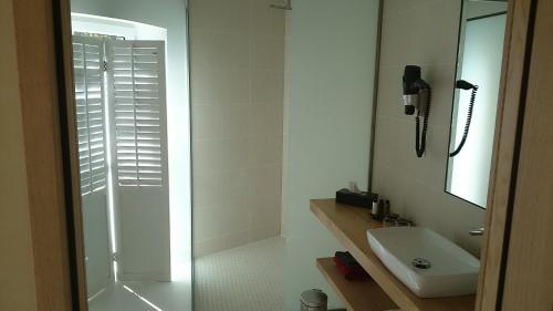 a white bathroom with a shower and a sink at L'Atelier De Dégustation in Vertus