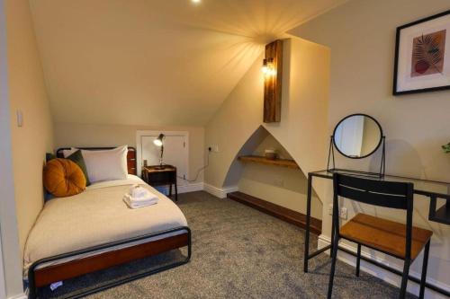 een slaapkamer met een bed en een trap met een spiegel bij The Chancery, Stunning Home Nr City Stadium, Principality Stadium and City Centre in Cardiff