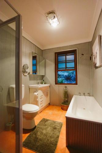 a bathroom with a tub and a toilet and a sink at Hinterland Retreat on 30 acres - Sleeps 6 in Broughton Village