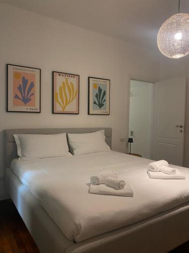 a bedroom with a white bed with towels on it at Palazzo Venezian 5 in Trieste