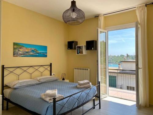 a bedroom with a bed and a large window at Le Grazie - Portovenere / Appartamento spazioso e luminoso con balconi vista mare aria condizionata e parcheggio (attenzione alle misure) in Le Grazie
