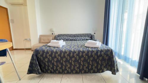 a bedroom with a bed with two towels on it at Le Due Farfalle Di Luciana Granella Monica e Deborah Albertin in Chioggia
