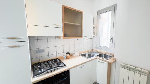 a small kitchen with a sink and a stove at Le Due Farfalle by Ca-Sa Check in Chioggia