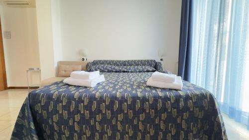 a bedroom with a bed with two pillows on it at Le Due Farfalle by Ca-Sa Check in Chioggia