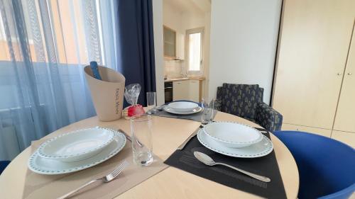 a table with plates and utensils on top of it at Le Due Farfalle by Ca-Sa Check in Chioggia