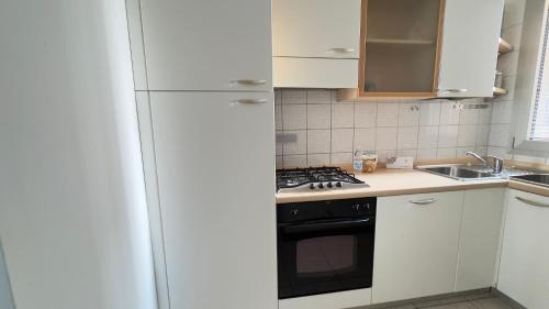 a kitchen with a white refrigerator and a stove at Le Due Farfalle by Ca-Sa Check in Chioggia