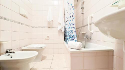 a white bathroom with a toilet and a sink at Le Due Farfalle by Ca-Sa Check in Chioggia