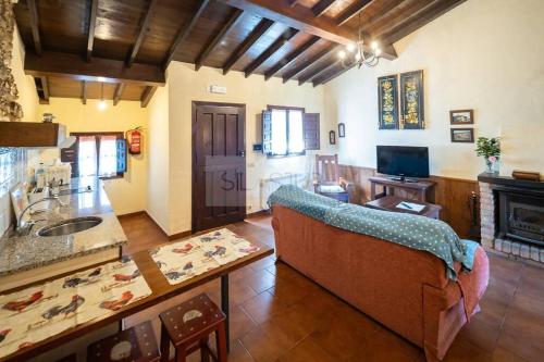 sala de estar con sofá y mesa en La Casona Del Cura I en Pravia