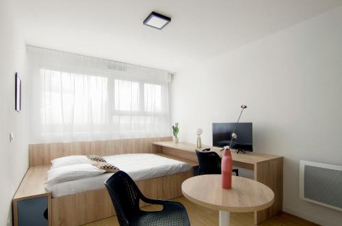 1 dormitorio con cama, escritorio y mesa en Sweetly I-Art, en Gradignan