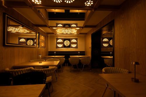 a dining room with tables and chairs and lights at Willa Zagroniówka in Istebna