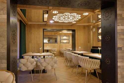 a restaurant with tables and chairs and a chandelier at Willa Zagroniówka in Istebna