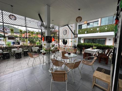restauracja ze stołami i krzesłami w budynku w obiekcie Infinity Resort Kohlarn w mieście Ko Larn