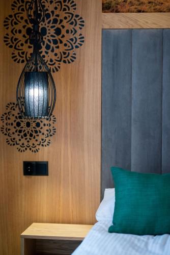 a bedroom with a chandelier hanging over a bed at Willa Zagroniówka in Istebna