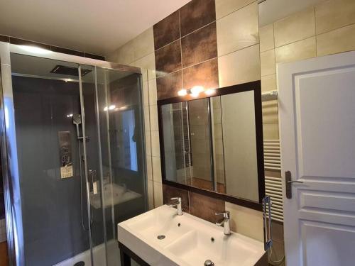 ein Badezimmer mit Waschbecken, Dusche und Spiegel in der Unterkunft Maison rénovée 4 chambres. in Angoulême