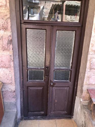 a wooden door with glass panels on a brick wall at Sweet house 1 in Gyumri