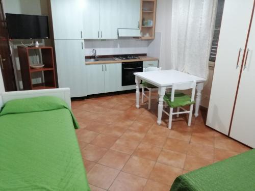 kuchnia ze stołem oraz niewielka kuchnia ze stołem i krzesłami w obiekcie Casa Chiara w mieście Scilla