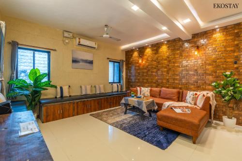阿利巴格的住宿－EKO STAY- PANORAMA VILLA，带沙发和砖墙的客厅