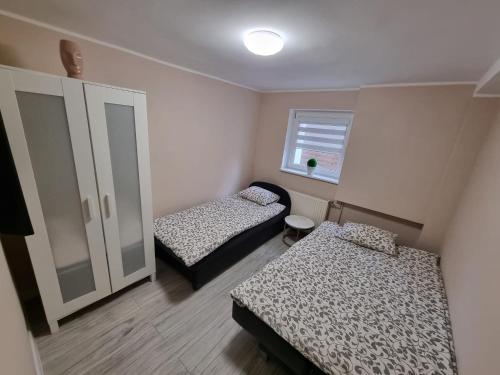 ステグナにあるApartament MASHOUSE Stegnaのベッド2台と窓が備わる小さな客室です。