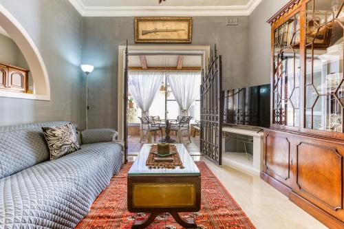 a living room with a couch and a table at A Lovely 3BR Maisonette in lovely town of Rabat by 360 Estates in Busugrilla