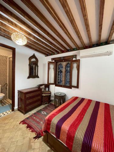 a bedroom with a large bed and a dresser at Dar Sababa in Chefchaouene