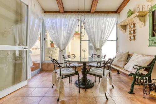 uma sala de jantar com uma mesa e cadeiras e um sofá em A Lovely 3BR Maisonette in lovely town of Rabat by 360 Estates em Busugrilla