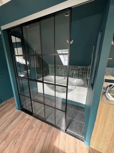 une douche en verre dans une salle de bain avec un lavabo dans l'établissement L’écrin de Rouen - Relax et Spa, à Rouen
