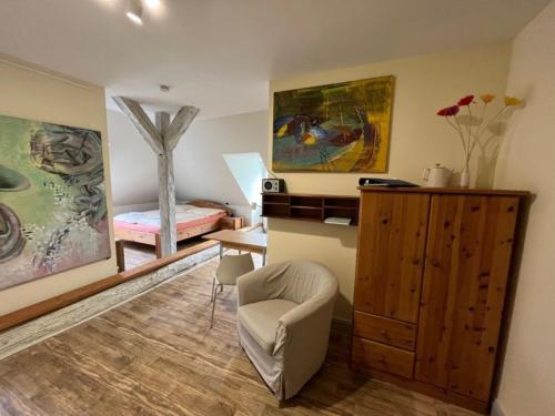 a living room with a chair and a bedroom at 2 Ferienwohnung - Ferien Mittendrin in Schwerin