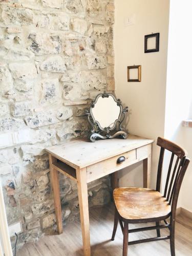 une table en bois avec un miroir sur un mur en pierre dans l'établissement Casa Barteèi, à Monte Isola