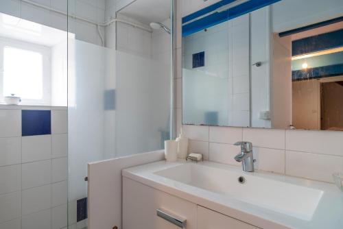 a white bathroom with a sink and a mirror at Le Sauzon - Vue sur le port - Proche de la plage in Sauzon