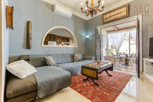 a living room with a couch and a table at A Lovely 3BR Maisonette in lovely town of Rabat by 360 Estates in Busugrilla