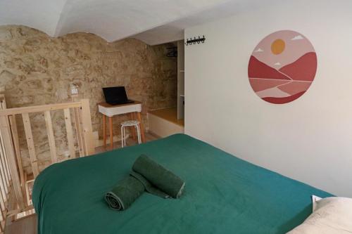 une chambre avec un lit vert avec un ordinateur portable sur une table dans l'établissement Studio climatisé mezzanine avec parking, à Montpellier