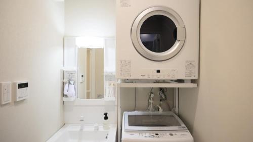 a washing machine in a kitchen with a microwave at Crice Hotel Ishigakijima in Ishigaki Island