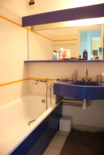 La salle de bains est pourvue d'un lavabo bleu et d'une baignoire. dans l'établissement Appartement familial avec vue sur la mer à Agay - 40 m² + piscine, à Agay