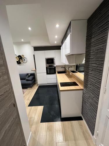 une cuisine avec des placards blancs et un sol noir dans l'établissement Port de Nice belle petite pépite, à Nice