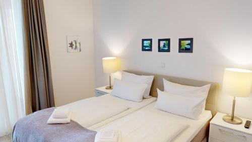 ペルツァーハケンにあるSüdkap G-03のベッドルーム1室(白いベッド1台、ランプ2つ付)