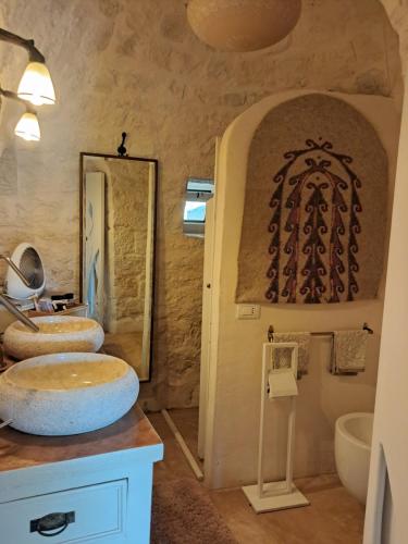 ein Badezimmer mit 2 Waschbecken und einem Spiegel in der Unterkunft Conibianchi Trulli&YurtArt House in Ceglie Messapica
