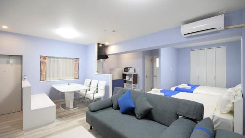 Sala de estar azul con sofá y cama en Crice Hotel Ishigakijima, en Ishigaki Island