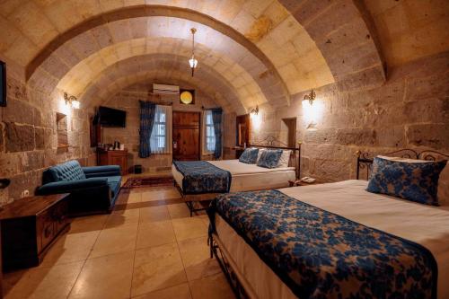 een grote kamer met 2 bedden en een bank bij Mithra Cave Hotel in Goreme