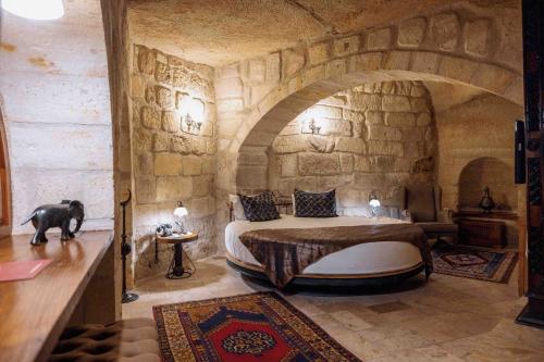 a bedroom with a bed in a stone room at Mithra Cave Hotel in Goreme