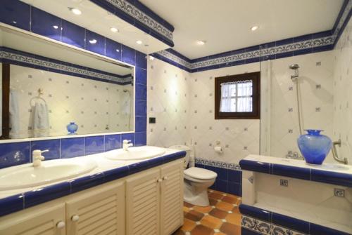 baño azul y blanco con lavabo y aseo en Club Villamar - Massia Lucrecia, en Maçanet de la Selva