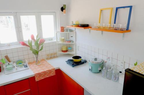 a kitchen with red cabinets and a white counter top at Joie Home in Nha Trang