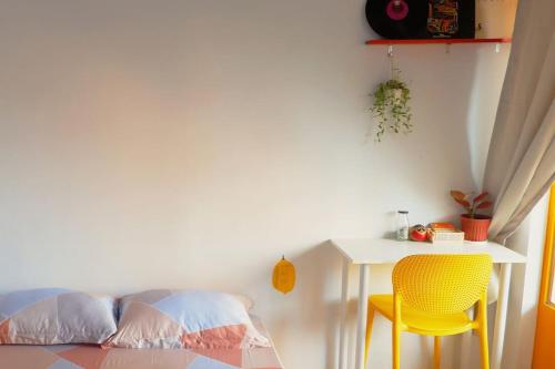a room with a table and a yellow chair and a desk at Joie Home in Nha Trang