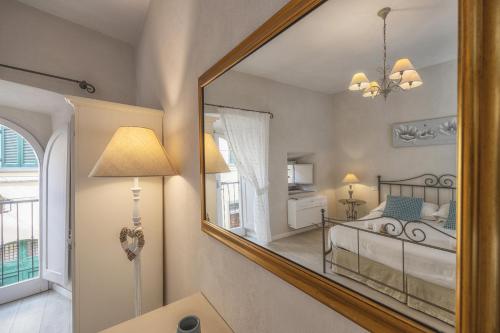 a mirror in a room with a bed and a bedroom at "Casa Tarconte" nel cuore di Cortona in Cortona
