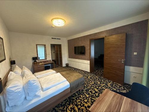 Habitación de hotel con cama y TV en Simbad Hotel & Bar Superior, en Mosonmagyaróvár