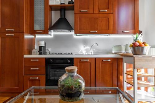 uma cozinha com uma mesa de vidro com um vaso sobre ela em Appartamento milano, Bruna House em Milão