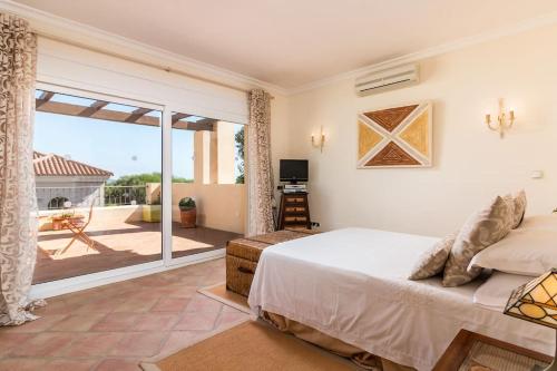 um quarto com uma cama e uma porta de vidro deslizante em El Castillo, a place to rest and enjoy em Sotogrande