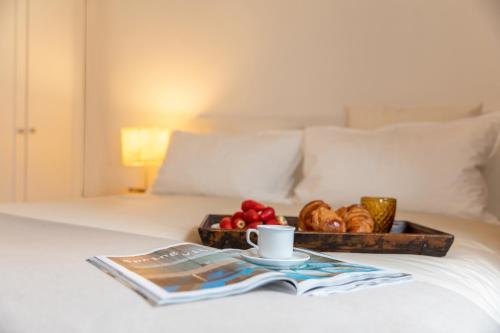 uma bandeja de pão e uma chávena de café numa cama em Appartamento milano, Bruna House em Milão