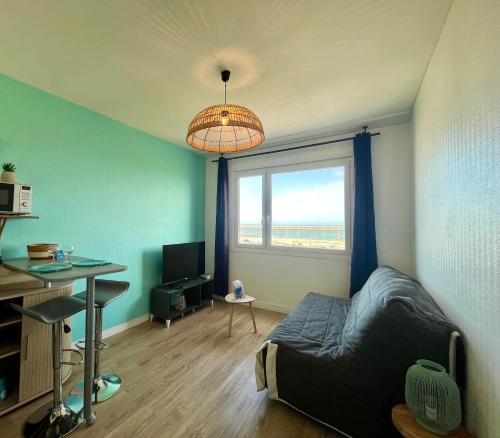 1 dormitorio con cama, escritorio y ventana en La Vague, en Calais
