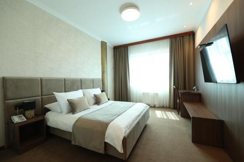 a hotel room with a bed and a television at Hotel Vidović in Banja Luka